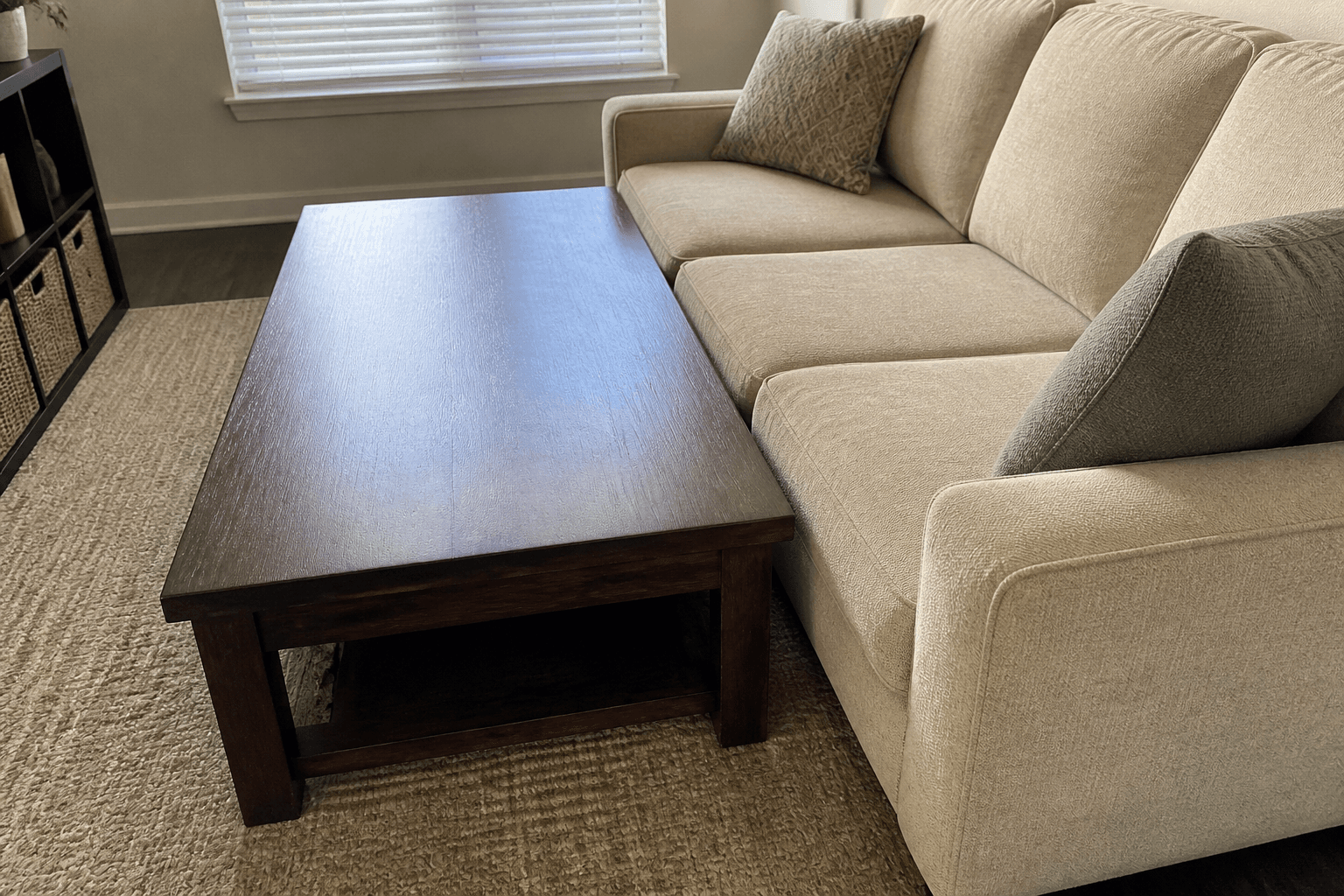 Large rectangular coffee table jammed against a beige sofa with no shin path