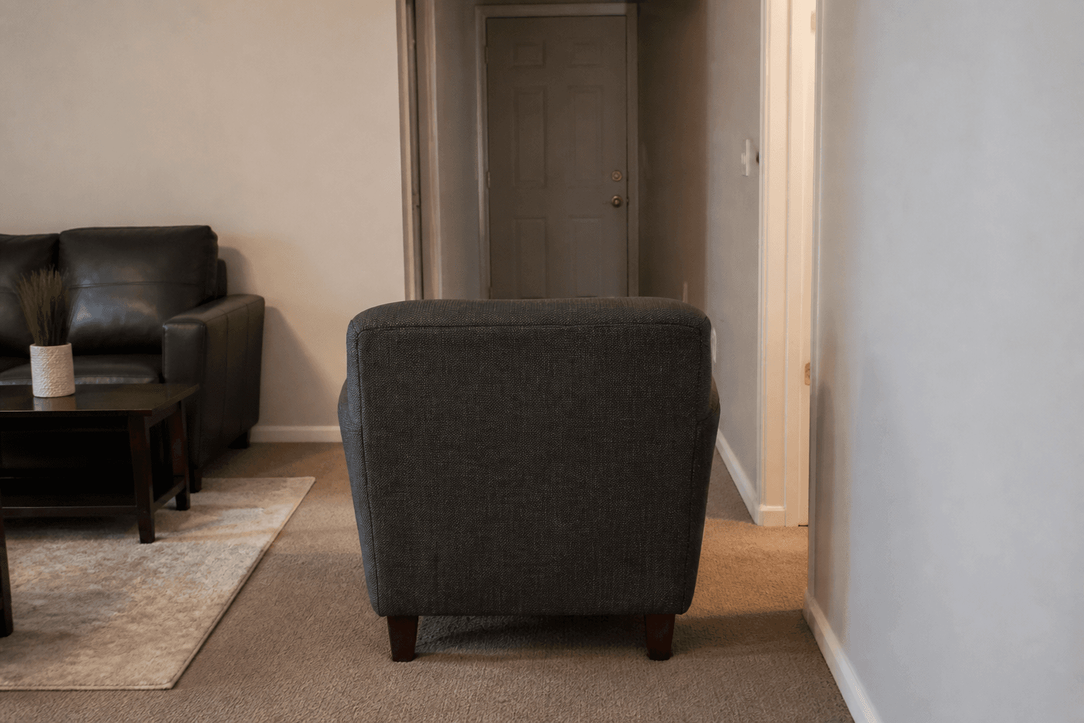 Armchair in the middle of the walk with its back to the room door and no lamp
