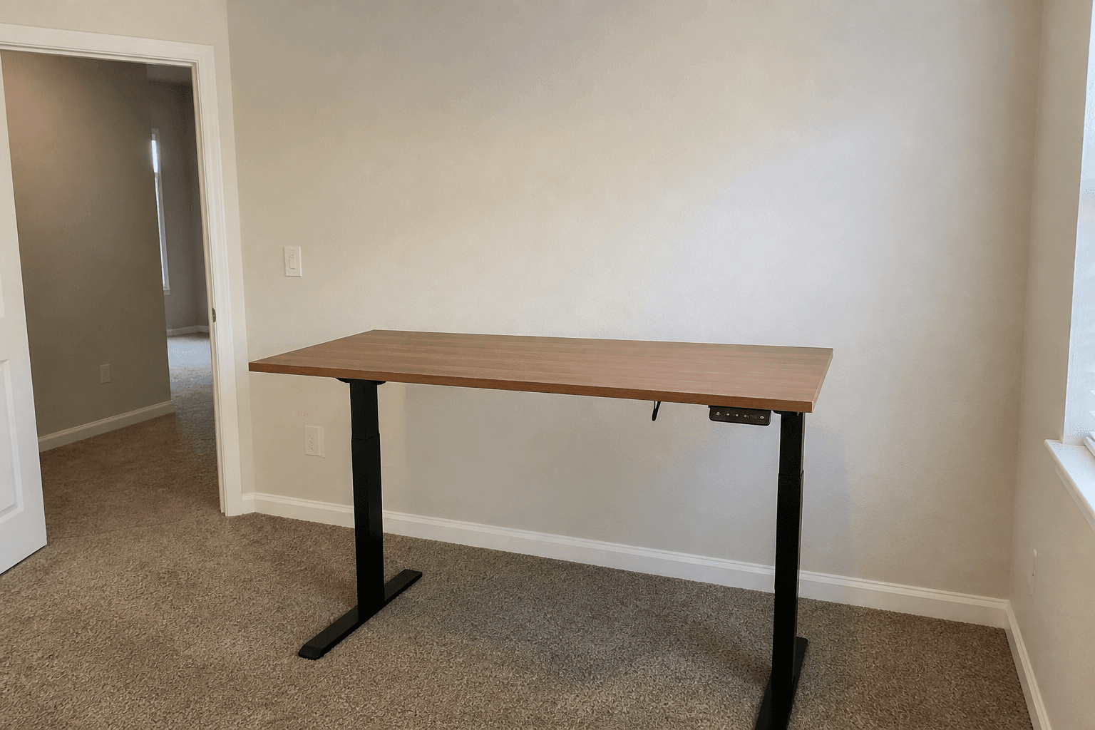 Standing desk aimed at a blank wall with the room door behind the standing spot