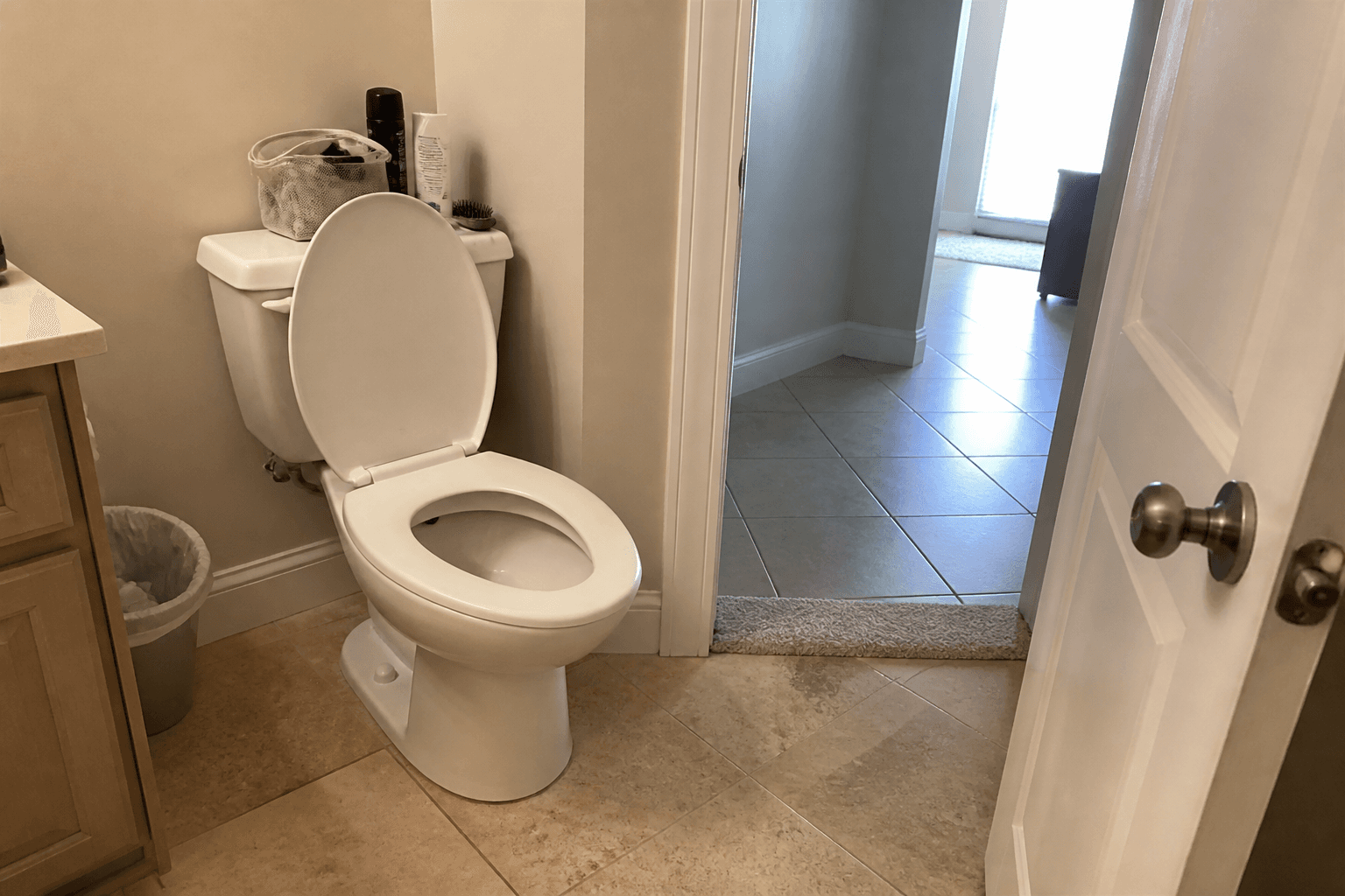 Upstairs bathroom with the toilet lid open and the door wide to the hall