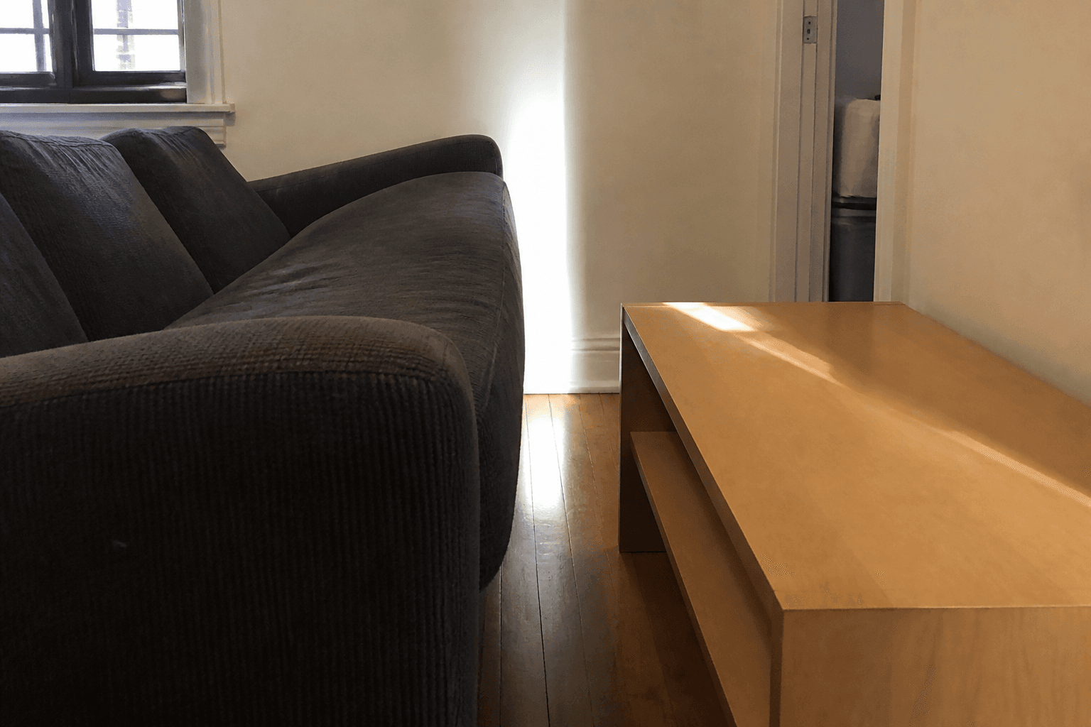 Too-large sofa pinching the walk between the arm and a coffee table in a small rental