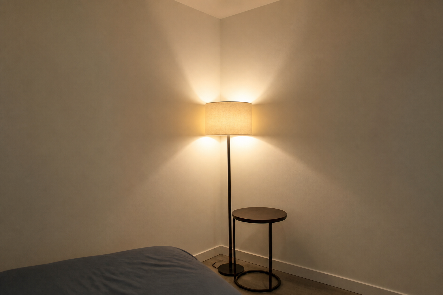 Inner corner of an L with a floor lamp and a small round table